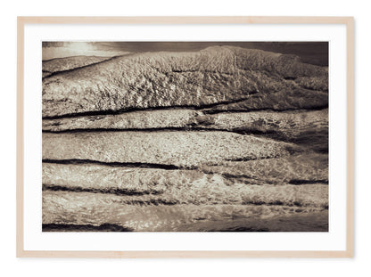 neutral tone landscape image of contrasty waves on shore